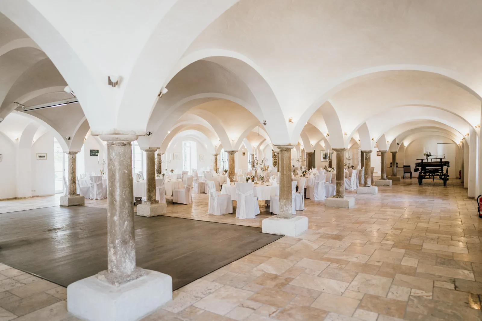 Historischer Gewölbesaal im Hofgut Sickertshofen bei München mit Travertin-Boden und Gewölbebögen