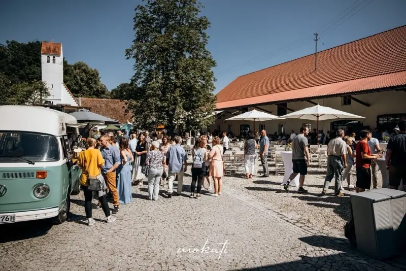 Firmenevent im Innenhof des Hofguts Sickertshofen bei Tag, mit Foodtruck und Gästen